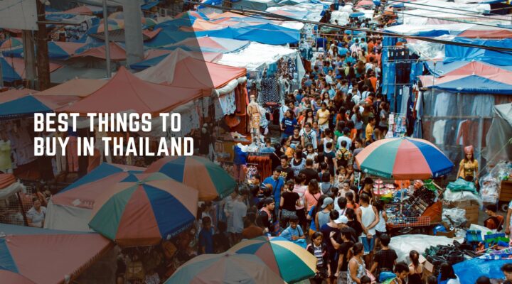 Crowded street market in Thailand with colorful umbrellas and shoppers exploring local goods and souvenirs.