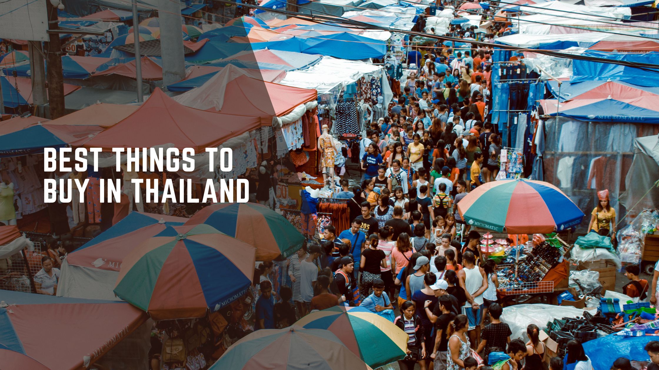 Crowded street market in Thailand with colorful umbrellas and shoppers exploring local goods and souvenirs.
